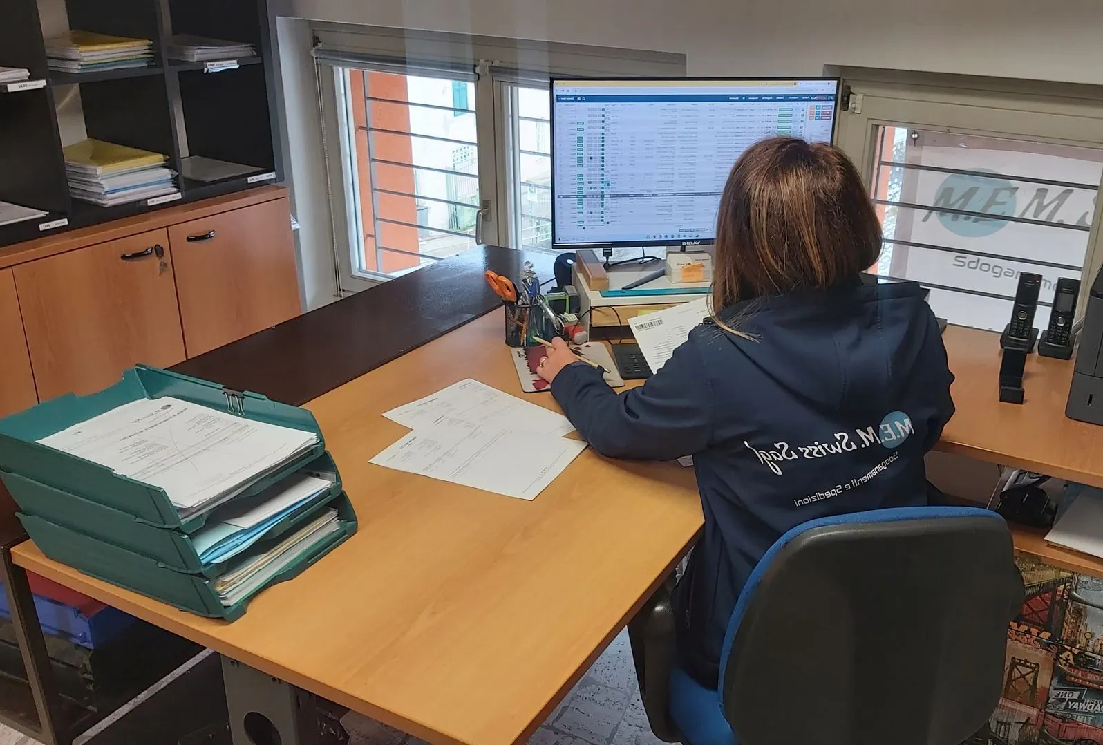Una collaboratrice di M.E.M. Swiss prepara le pratiche in ufficio